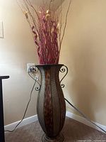 Full view of metal floor vase with branch decor