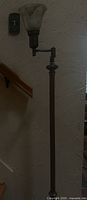 Full view of floor lamp showing swing arm and glass shade