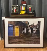 Front view showing large framed print, four small framed prints and red vase