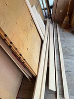 Stack of plywood offcuts including large panel and narrow strips