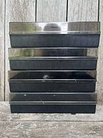 Stack of four cassette storage trays with lids