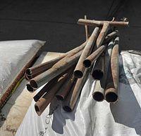 Bundle of copper pipe sections piled on plastic-covered surface