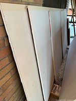 Stack of full drywall panels against wall