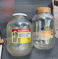 Front view of both glass jars showing labels and stoppers