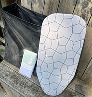 Hamper, ironing board, packaged mesh bag side by side