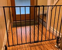 Full view of dark brown metal gate with latch installed in doorway