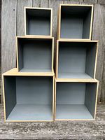 Front view of six graduated wooden cube shelves showing interiors