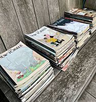 Three tall stacks of New Yorker magazines on bench