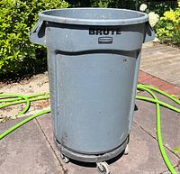 Full view of grey Rubbermaid Brute trash can on dolly