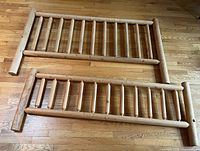 Headboard and footboard laid on floor showing spindle design