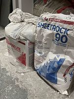 Bag of CGC Sheetrock 90 and box of CGC All Purpose Lite drywall compound