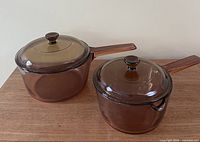 Two Corning Visions saucepans with lids displayed