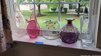 All five vases lined on windowsill showing relative sizes and colors