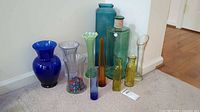 Group view of all glass vases and bottles on carpet