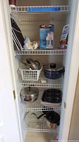 Pantry shelves showing multiple cookware pieces and accessories