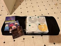 Open carrying binder showing sleeve pages with DVDs and additional jewel cases