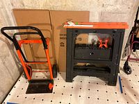 Hand truck and sawhorse standing side by side