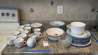 Full lot overview on counter showing stacks of plates, bowls, cups