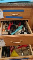 Drawer of assorted utensils showing mixed materials and colours
