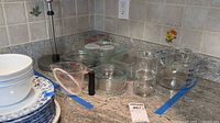 Group view of measuring cups, bowls, lids, glasses, loaf pan and paper towel holder