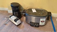 All three appliances grouped: Cuisinart multi-cooker with rack, Mr. Coffee maker, Chef’sChoice sharpener