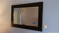 Full view of rectangular wall mirror hanging on wall