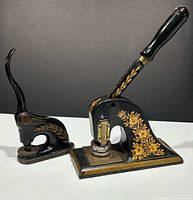 Both cast iron seal presses side by side showing decorative paint and handles