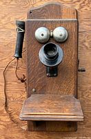 Front view showing entire telephone, bells, mouthpiece, receiver, writing shelf