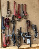 Overall pegboard view of all pipe cutters, wrenches, chain wrench and accessories
