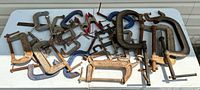 Full lot of assorted clamps spread on table