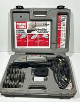 Open carry case showing sander, accessories, and instruction chart