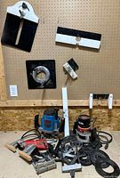 Full lot with two routers, insert plates and accessories on floor and pegboard