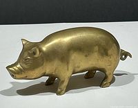 Left side profile of brass pig figurine