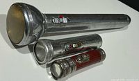 Three flashlights grouped showing relative sizes and switches