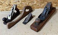 Group shot of Bailey transitional plane, Stanley bench plane, separate iron assembly, and curved wooden handle piece