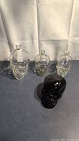 Group shot of four glass skull bottles