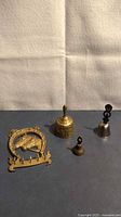 Overview of four brass items: key rack, large bell, small bell, silver-tone bell