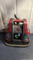 Front view of Hoover Spotless wet vacuum showing brand badge, hose and tank