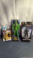 Overview of the three packaged action figures side by side