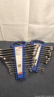 Two combination wrench sets in blue plastic racks