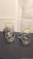 Tall and handled NutriBullet cups upside down showing blades