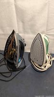 Both irons standing on soleplates showing underside patterns