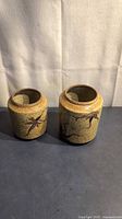both signed speckled pottery vases side by side