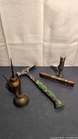 Group shot of hammer, flashlight, level, oil can