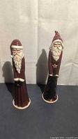 Both tall Santa figurines standing upright