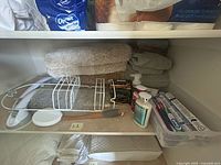 Shelf with towels, wire baskets, bath mat, grab bar, toiletry items