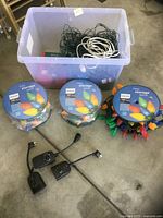overall lot showing storage tote filled with lights, three Philips spools, loose C9 string, two timers