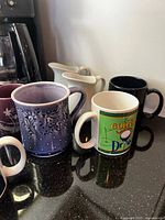 Mugs and creamers beside coffee maker