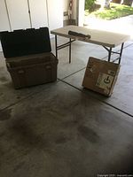 Overall view of folded table, open storage tote, boxed umbrella base