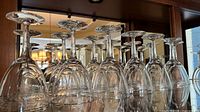 Row of upside-down crystal wine glasses on shelf